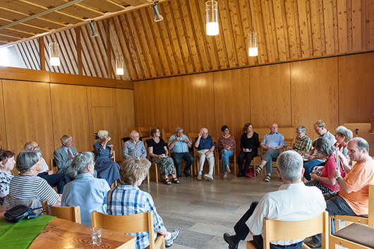 Blick in den groen Gemeinderaum, wo die Teilnehmer des Predigtnachgesprchs im Kreis sitzend diskutieren.